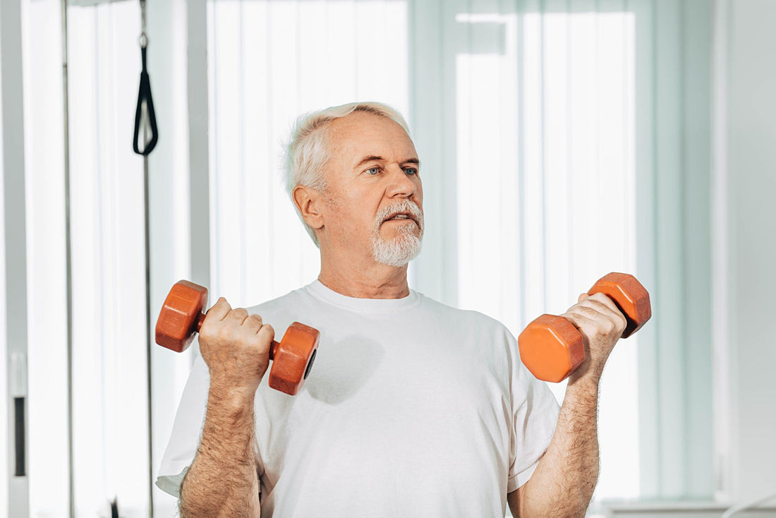 Older man exercising with dumbbells indoors