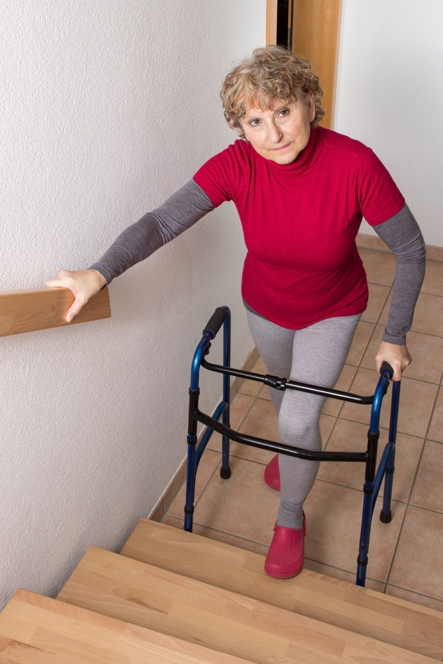 Older adult using a handrail while stepping down stairs