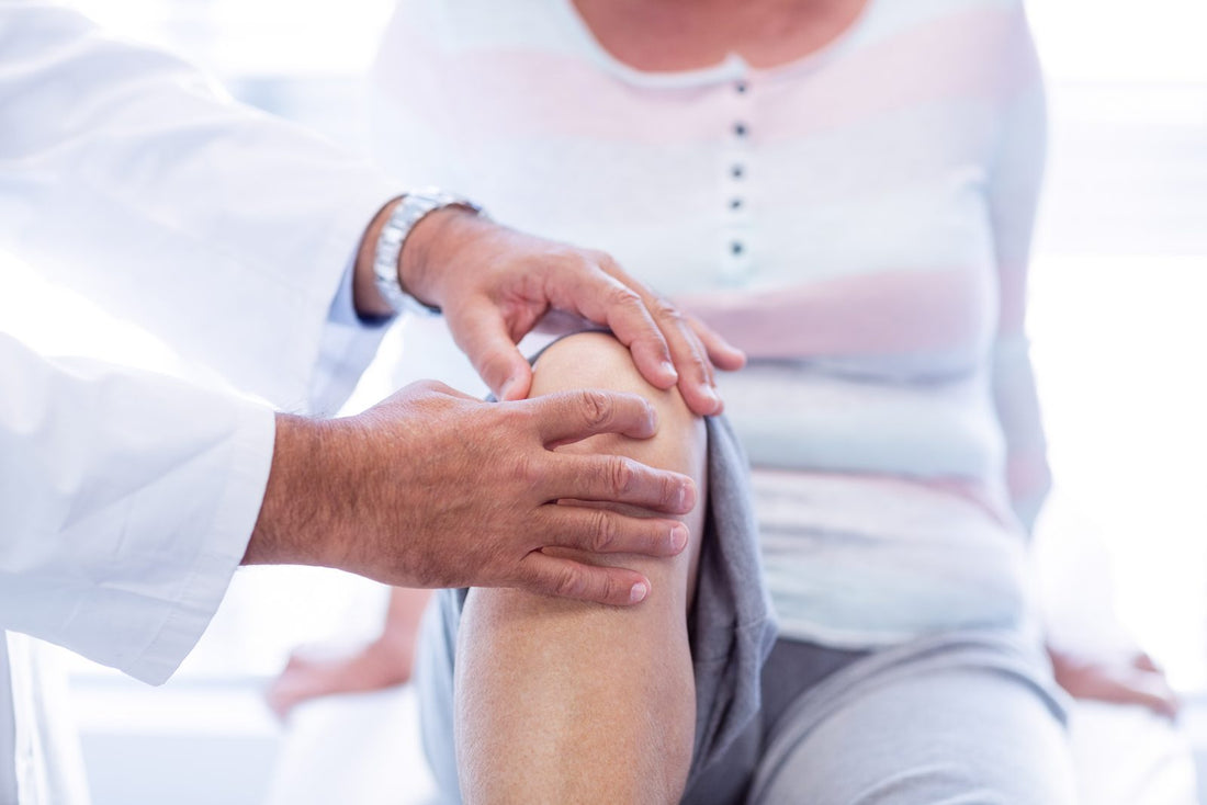 Physiotherapist giving knee therapy to a senior woman