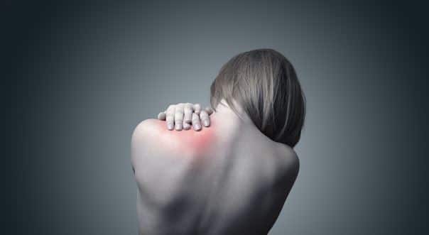 Woman holding the back of her neck with one hand