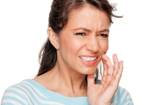 Person pressing a hand to their cheek with a toothache