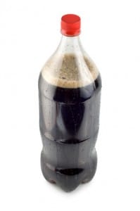 Glass bottle of dark soda isolated on a white background