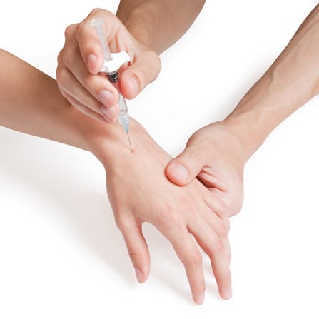 Doctor giving an injection into a patient's knee joint