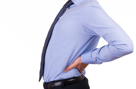 Businessman in a shirt and tie holding his lower back