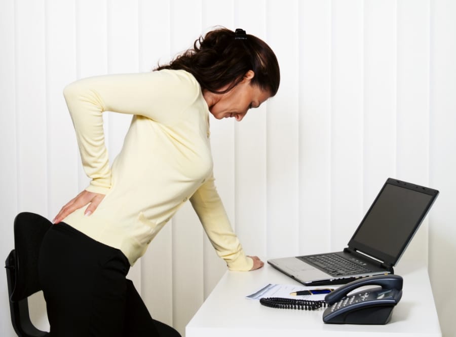 Person in a yellow outfit bending forward indoors