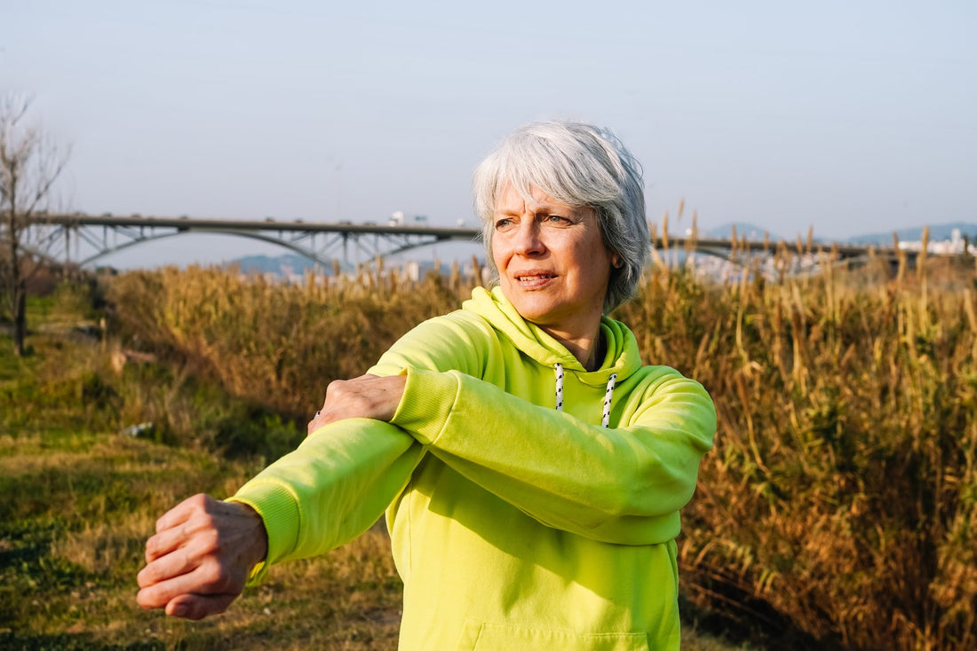 Active senior woman warming up and stretching outdoors