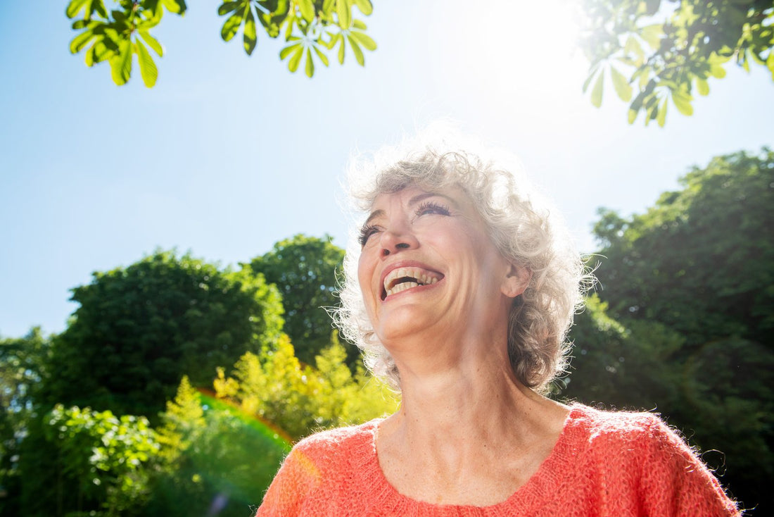 Smiling older woman enjoying sunshine outdoors